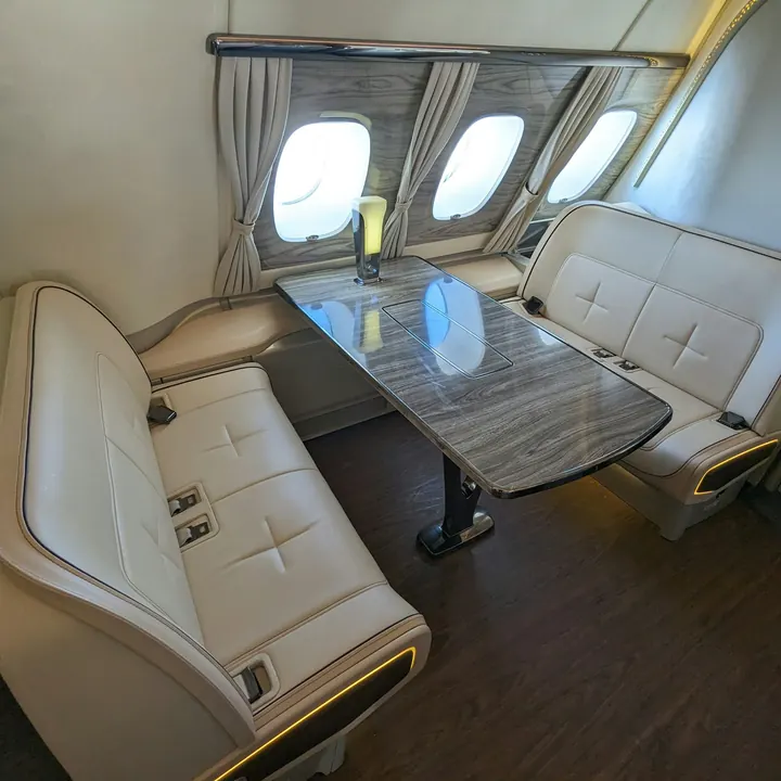 Club seating around a polished table in a private jet cabin